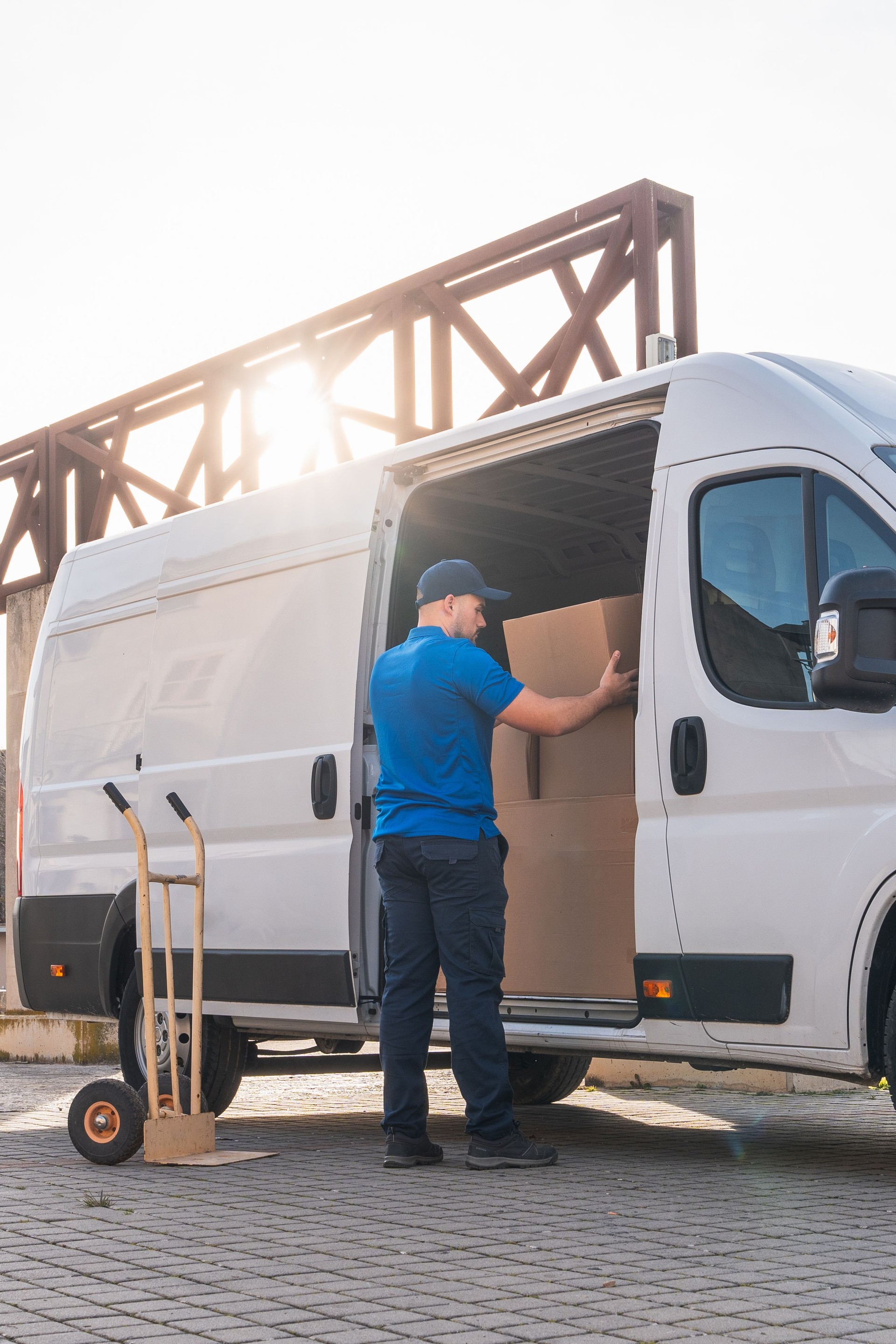 Courier Loading Boxes into Delivery Van at Sunset